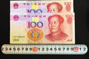 “加长版”百元钞票对比，明显比其它钞票长一点，防伪线和字体的位置也不同。 杨伟广 图